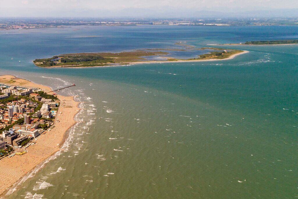 Vista aerea di una costa con spiaggia e isole al largo.
