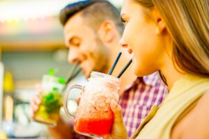Due persone che bevono cocktail rinfrescanti con cannucce.