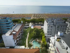 Veduta aerea di hotel e piscina con spiaggia sullo sfondo.