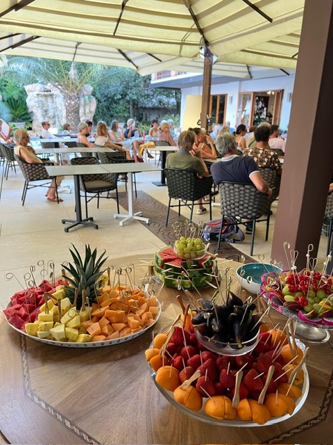 Sala piena di persone con centrotavola di frutta pronti da servire